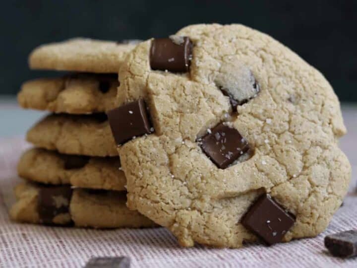 Stack of freshly baked protein cookies with dark chocolate chunks, offering a healthier alternative for satisfying sweet cravings, made using whey protein powder