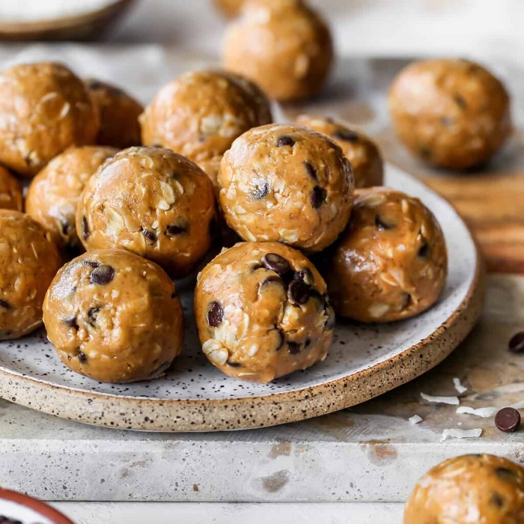 Plate of no-bake protein energy balls made with peanut butter, oats, and chocolate chips, offering a healthy, high-protein snack option.